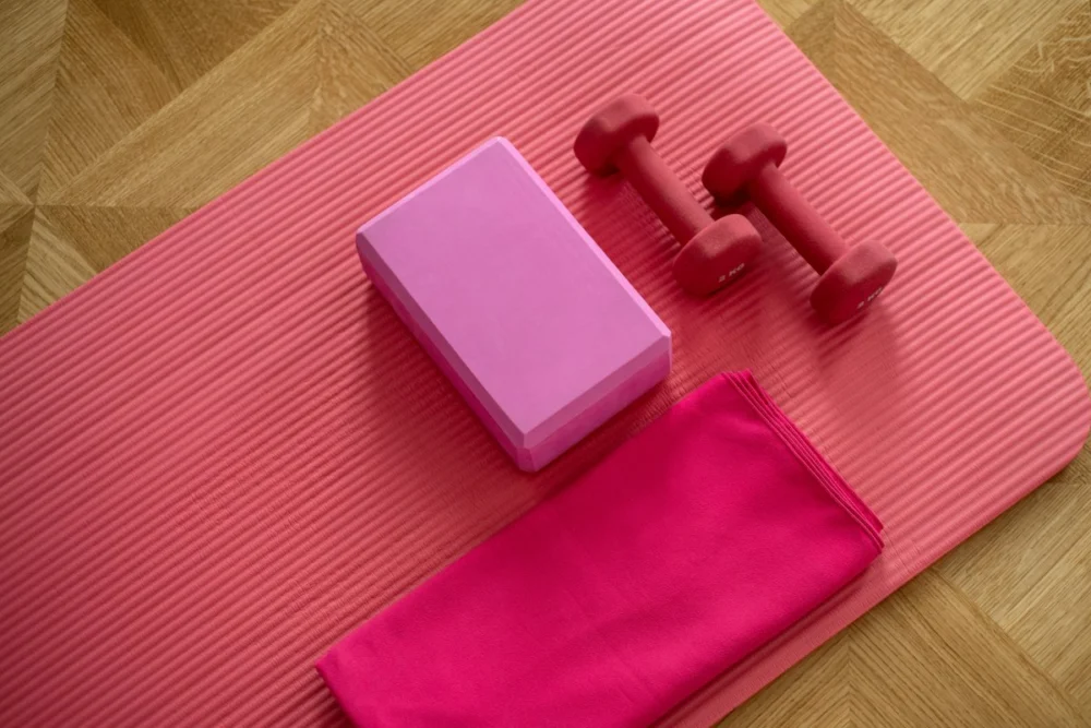 Exercise mat and hand weights laid out for a gym workout